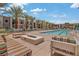 Luxurious pool area with comfortable lounge seating, fire pit, and palm trees at 353 E Bonneville Ave # 375, Las Vegas, NV 89101