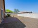 A spacious backyard with gravel, brick patio, and a white fence, perfect for outdoor activities and relaxation at 4016 Balsam Mountain St, Las Vegas, NV 89129