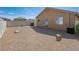 A spacious backyard with gravel, brick patio, and a white fence, perfect for outdoor activities and relaxation at 4016 Balsam Mountain St, Las Vegas, NV 89129