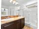 Bathroom featuring a double sink vanity, shower with glass door, and wood-look floors at 4016 Balsam Mountain St, Las Vegas, NV 89129