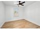Bedroom with wood-look floors, ceiling fan, and bright natural light from the window at 4016 Balsam Mountain St, Las Vegas, NV 89129