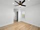 Bedroom with wood-look floors, ceiling fan, and bright natural light from the window at 4016 Balsam Mountain St, Las Vegas, NV 89129