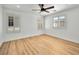 Spacious bedroom with wood-look floors, ceiling fan, and bright natural light from the windows at 4016 Balsam Mountain St, Las Vegas, NV 89129