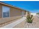 Tan house with desert landscaping, concrete walkway, and a white security door at 4016 Balsam Mountain St, Las Vegas, NV 89129