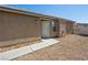 Side view of a stucco home featuring a gravel yard, concrete walkway and security door at 4016 Balsam Mountain St, Las Vegas, NV 89129