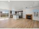 Open-concept living space with wood floors, a corner fireplace, stainless appliances, and a kitchen island at 4016 Balsam Mountain St, Las Vegas, NV 89129