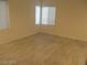 Bright bedroom with wood-style flooring and two windows lets in ample natural light at 5481 Railroad River Ave, Las Vegas, NV 89139