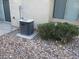 Exterior view featuring an AC unit, a window, decorative stones, and partial view of sliding glass door at 5481 Railroad River Ave, Las Vegas, NV 89139