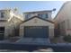 Two story home featuring a gray garage door and stucco facade with a well maintained lawn at 5481 Railroad River Ave, Las Vegas, NV 89139