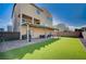 Spacious backyard featuring a covered patio, artificial turf, and low-maintenance landscaping at 5946 Ancient Peaks Ave, Las Vegas, NV 89141