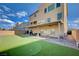 Inviting backyard with putting green, covered patio with fan and ample seating, and pavers at 5946 Ancient Peaks Ave, Las Vegas, NV 89141