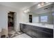 Dual sink bathroom vanity with modern lighting, large mirror, and an adjacent walk-in closet at 5946 Ancient Peaks Ave, Las Vegas, NV 89141