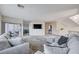 Spacious living room featuring neutral-colored furniture, a large area rug and a TV mounted above built in shelving at 5946 Ancient Peaks Ave, Las Vegas, NV 89141