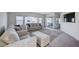An airy living room featuring neutral colored sofas, a TV, and large windows that provide lots of natural light at 5946 Ancient Peaks Ave, Las Vegas, NV 89141