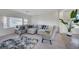 A sunlit living room featuring a gray sectional sofa, a patterned rug, and an accent chair with a yellow pillow at 5946 Ancient Peaks Ave, Las Vegas, NV 89141