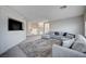 Spacious living room featuring neutral-colored furniture, a large area rug and a TV mounted on the wall at 5946 Ancient Peaks Ave, Las Vegas, NV 89141