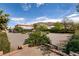 Expansive backyard with gravel, mountain views, and two story home with covered patio and pergola at 6915 Cedar Basin Ave, Las Vegas, NV 89142