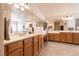 Bathroom with double sinks, lots of mirrors, lots of counter space and wooden cabinets at 6915 Cedar Basin Ave, Las Vegas, NV 89142