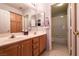 Bright bathroom with dual sinks, wood cabinets, and a separate shower area at 6915 Cedar Basin Ave, Las Vegas, NV 89142