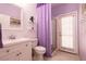 Clean bathroom with white vanity, purple accents, and a separate shower at 6915 Cedar Basin Ave, Las Vegas, NV 89142