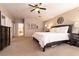 Neutral-toned bedroom features carpet, decorative lighting, dark furnishings and white bedding at 6915 Cedar Basin Ave, Las Vegas, NV 89142