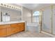 Bathroom featuring a double sink vanity, a large mirror, a soaking tub, and a shower with glass doors at 7425 Enchanted Hills Ct, Las Vegas, NV 89129
