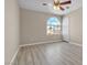 This is a well-lit bedroom with light colored wood floors and a large arched window with neighborhood views at 7425 Enchanted Hills Ct, Las Vegas, NV 89129