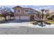 Inviting two-story home with a three-car garage, palm trees, and a neatly kept front yard at 7425 Enchanted Hills Ct, Las Vegas, NV 89129