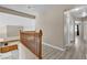 Bright hallway featuring wood floors and railings with a view into the kitchen below at 7425 Enchanted Hills Ct, Las Vegas, NV 89129