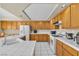 Bright kitchen with white appliances, tile countertops and light wood cabinets at 7425 Enchanted Hills Ct, Las Vegas, NV 89129