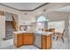Kitchen island with white tile countertops and light wood cabinets. Stairs and Kitchen table nearby at 7425 Enchanted Hills Ct, Las Vegas, NV 89129