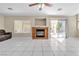 Spacious living room with a brick fireplace, tile flooring, large window and sliding door to backyard at 7425 Enchanted Hills Ct, Las Vegas, NV 89129