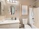 Bathroom features a single sink vanity, round mirror, and shower and tub combo at 7690 Blue Whirlpool St, Las Vegas, NV 89131
