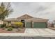 Single-story home featuring a three-car garage, desert landscaping, and tile roof at 7690 Blue Whirlpool St, Las Vegas, NV 89131