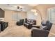 Cozy living room features neutral walls, carpet floors, a ceiling fan and plantation shutters at 7690 Blue Whirlpool St, Las Vegas, NV 89131