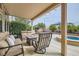 Comfortable covered patio with seating, a fire pit, and views of the backyard and play area at 7690 Blue Whirlpool St, Las Vegas, NV 89131