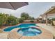 Inviting pool and spa surrounded by lush landscaping and a spacious patio area at 7690 Blue Whirlpool St, Las Vegas, NV 89131