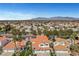 An aerial view of a neighborhood with red tile roofs shows a vast city in the distance with mountain views at 8132 Bay Harbor Dr, Las Vegas, NV 89128