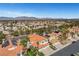 Expansive aerial view of a neighborhood featuring homes with desert landscaping and terra cotta roofs, set against distant mountains at 8132 Bay Harbor Dr, Las Vegas, NV 89128