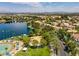 An aerial view shows community amenities with pool, recreation area and lake on a sunny day at 8132 Bay Harbor Dr, Las Vegas, NV 89128