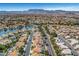 Expansive aerial view of a neighborhood featuring tree lined streets and a lake at 8132 Bay Harbor Dr, Las Vegas, NV 89128