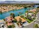 An aerial view shows a waterfront neighborhood featuring terracotta roofs and mature palm trees at 8132 Bay Harbor Dr, Las Vegas, NV 89128