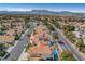 Beautiful aerial view showcasing a neighborhood with terra cotta-roofed homes, desert landscaping, and community lakes at 8132 Bay Harbor Dr, Las Vegas, NV 89128