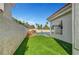 A bright green lawn abuts the rear of a white home with red tile roof and a swimming pool at 8132 Bay Harbor Dr, Las Vegas, NV 89128