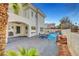 Exterior of home with a covered patio and landscaped pool area including a rock waterfall at 8132 Bay Harbor Dr, Las Vegas, NV 89128
