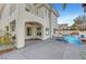 View of the backyard featuring a covered patio, a pool with a waterfall, and mature landscaping at 8132 Bay Harbor Dr, Las Vegas, NV 89128