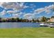 Beautiful waterfront community with lush green lawns, palm trees, and a dock with boats on the lake at 8132 Bay Harbor Dr, Las Vegas, NV 89128