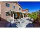 Exterior view of back of house with covered patio, desert landscaping and lights at 9849 Ridge Hill Ave, Las Vegas, NV 89147