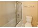 Bright bathroom featuring a shower-over-tub with glass door and a white toilet at 9849 Ridge Hill Ave, Las Vegas, NV 89147