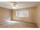 Carpeted bedroom with a ceiling fan, neutral walls, and a large window for natural light at 9849 Ridge Hill Ave, Las Vegas, NV 89147